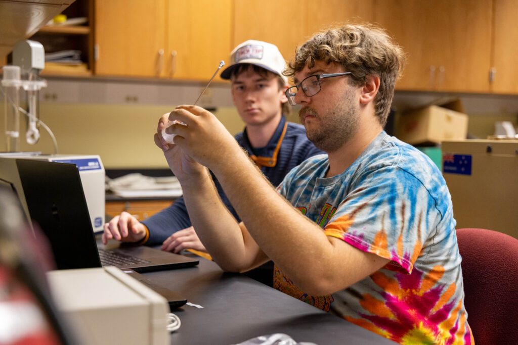 Jamie McCarthy '27, at right, measures the iron-bearing materials in rock samples with Ryan Britt '27.